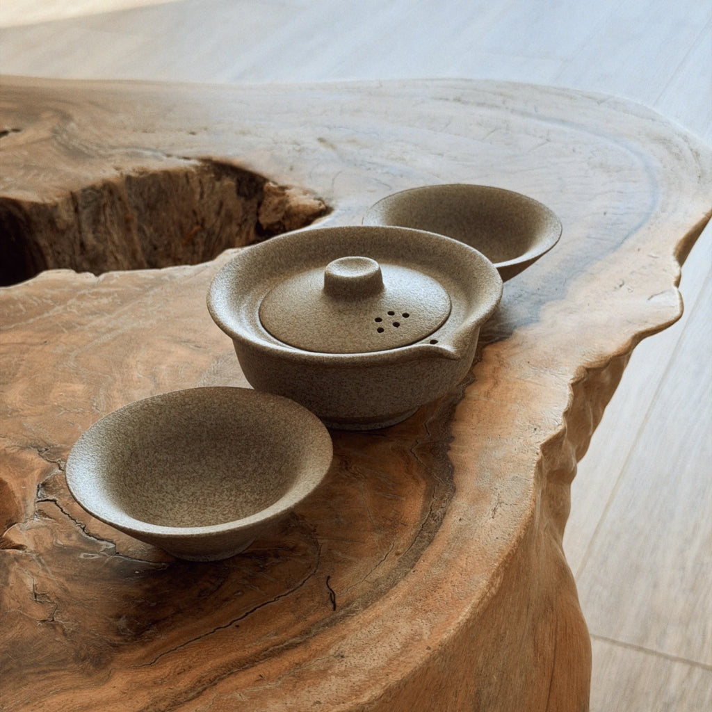 Beige ceramic gaiwan tea set with two cups on natural wood slab