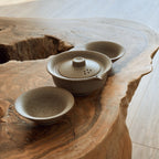 Beige ceramic gaiwan tea set with two cups on natural wood slab