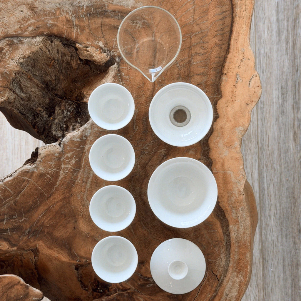 complete gaiwan set components laid flat — gaiwan, cha hai, strainer, and 4 cups top view